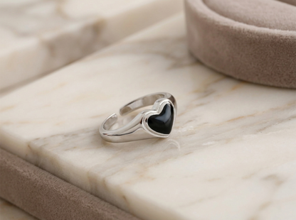 Silver heart ring with black center, side profile view