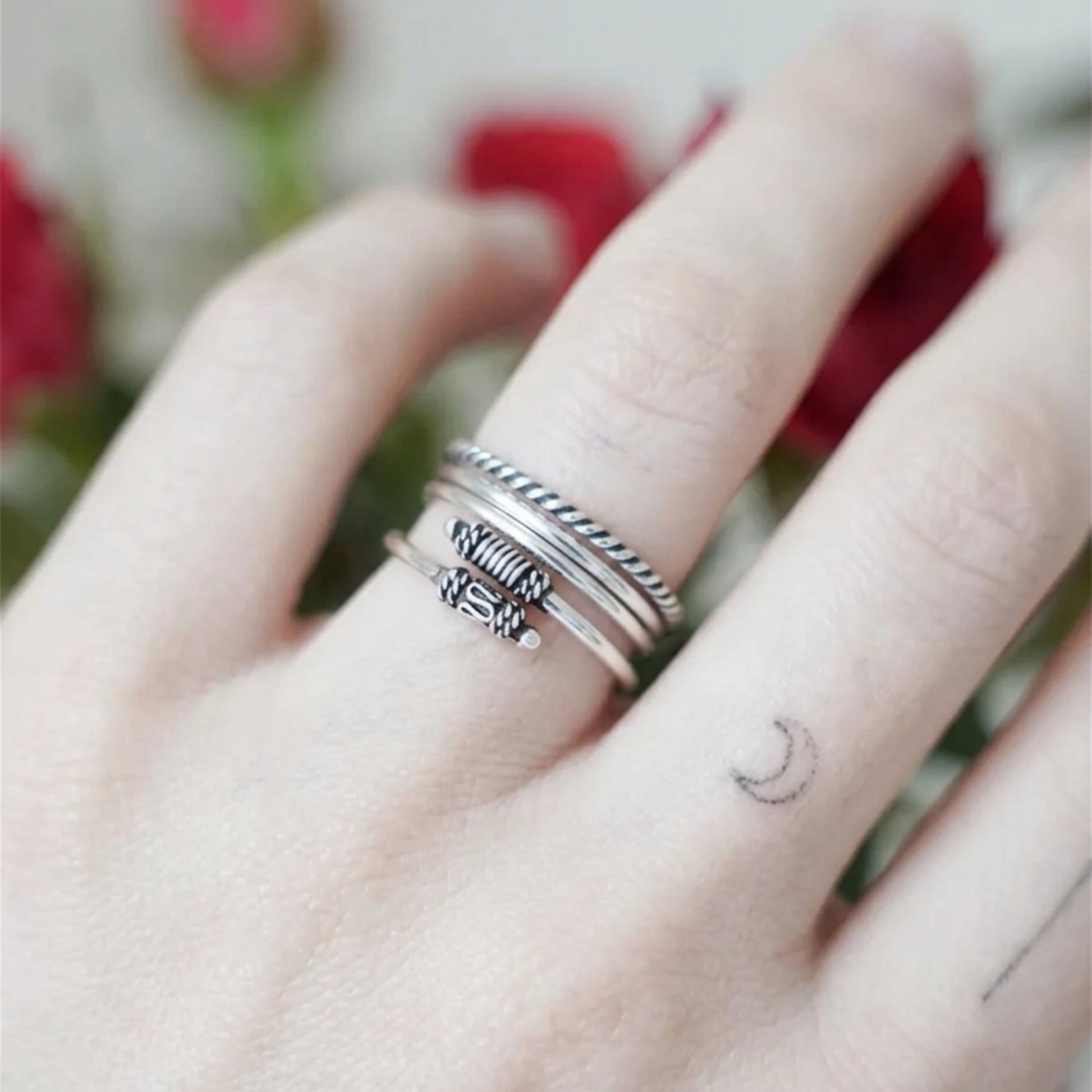 Oxidized silver totem knot ring on finger, ridged bands with raised knot centerpiece