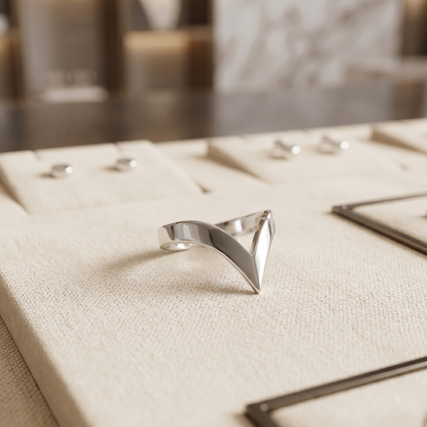 Silver wishbone V ring on a light fabric surface, angled view of the open V.