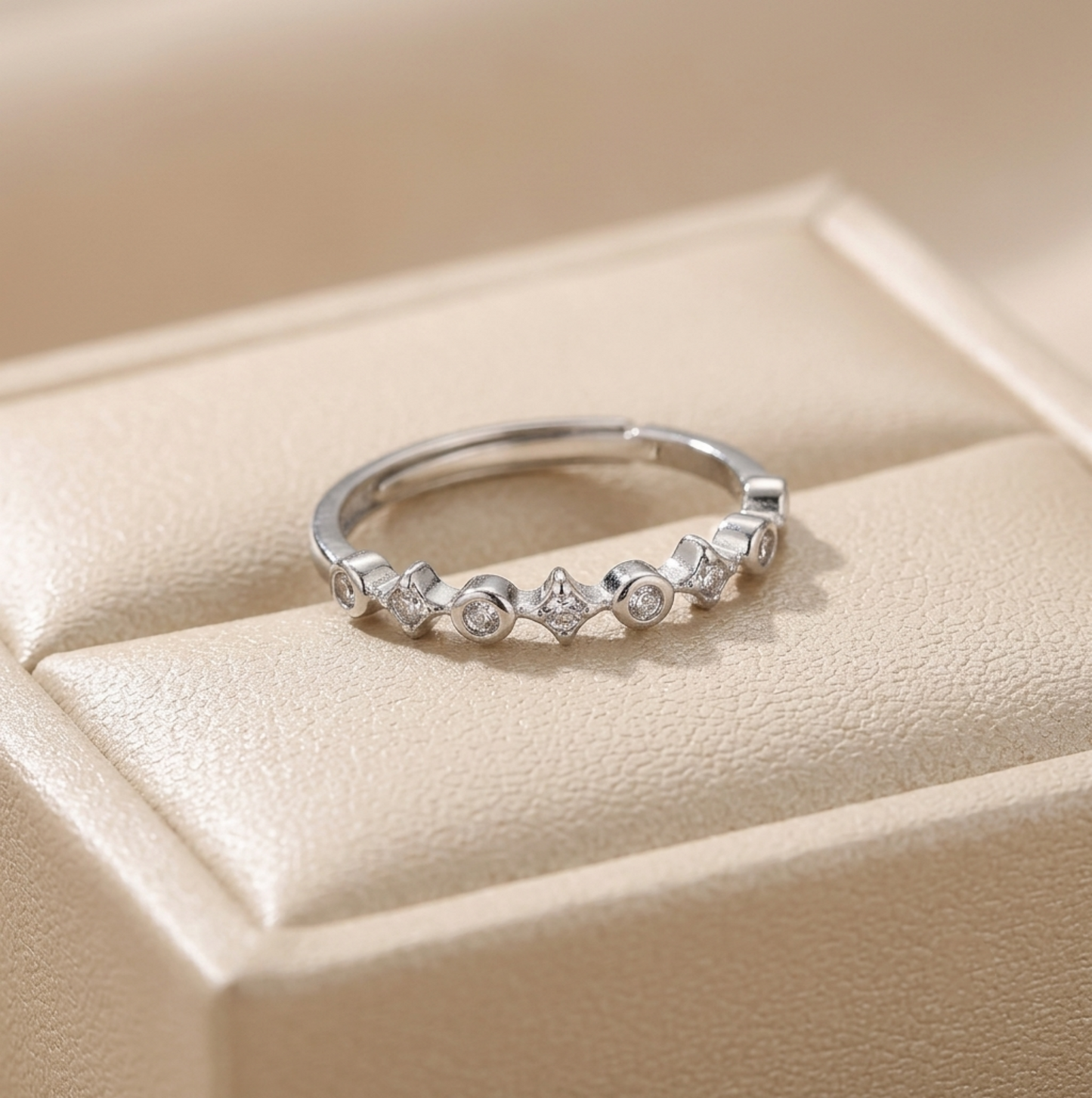 Silver CZ ring with small round stones in star-shaped bezels across the band