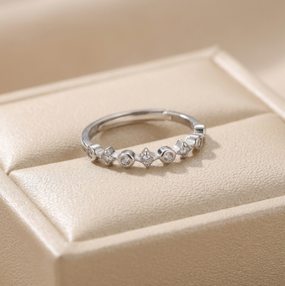 Silver CZ ring with small round stones in star-shaped bezels across the band