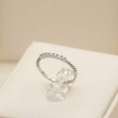 Silver half-eternity beaded ring with small clear stones in a half row.