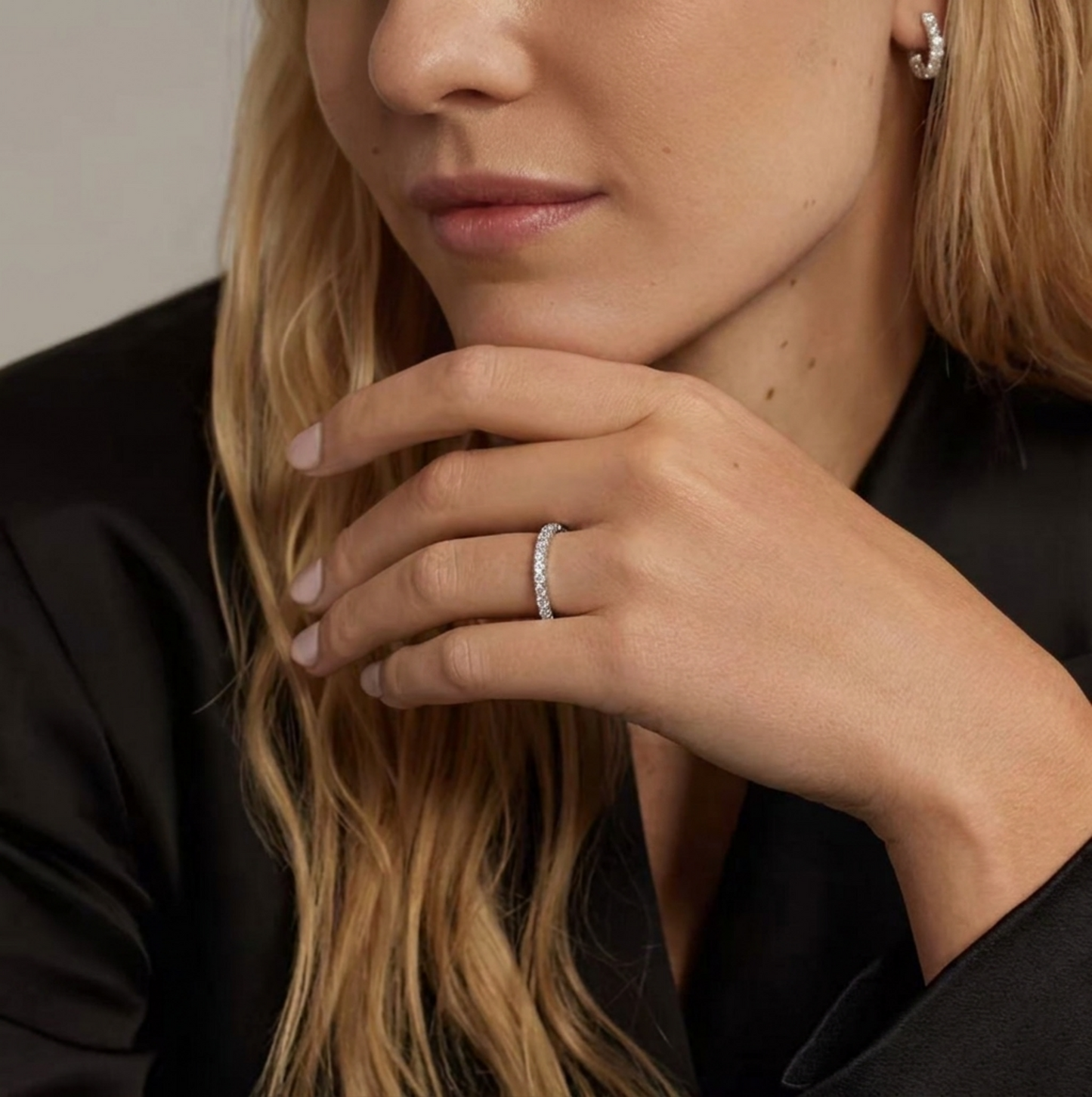 CZ stacking eternity band ring in silver tone on finger with a row of sparkle stones