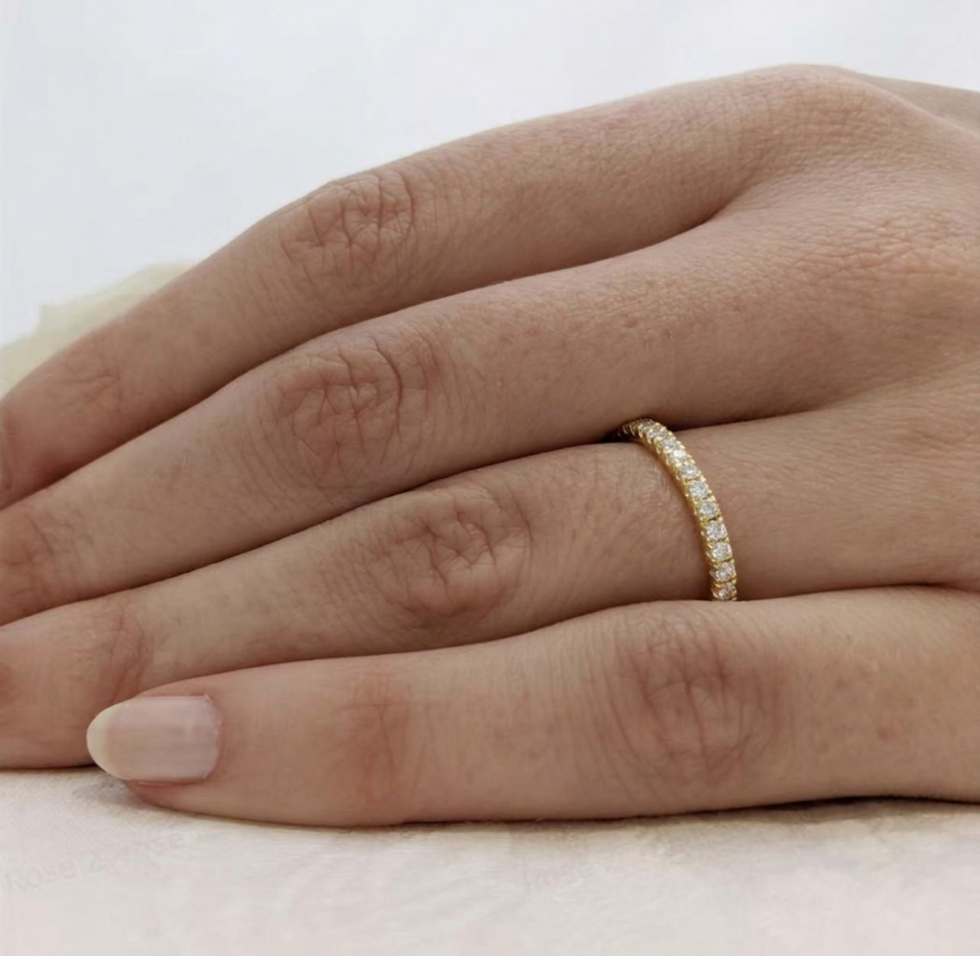 CZ stacking eternity band ring in gold tone worn on a hand, with bright sparkle stones