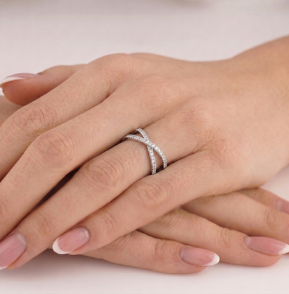 Infinity criss-cross ring on hand, silver-tone band with pavé stones