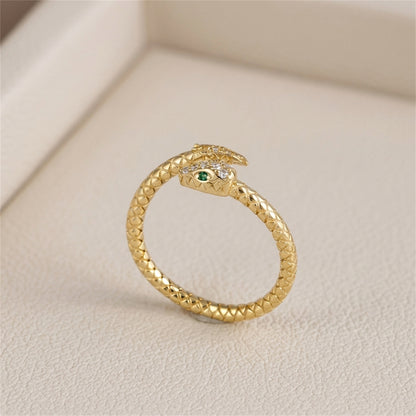 Gold-tone snake wrap ring with green eye on textured band