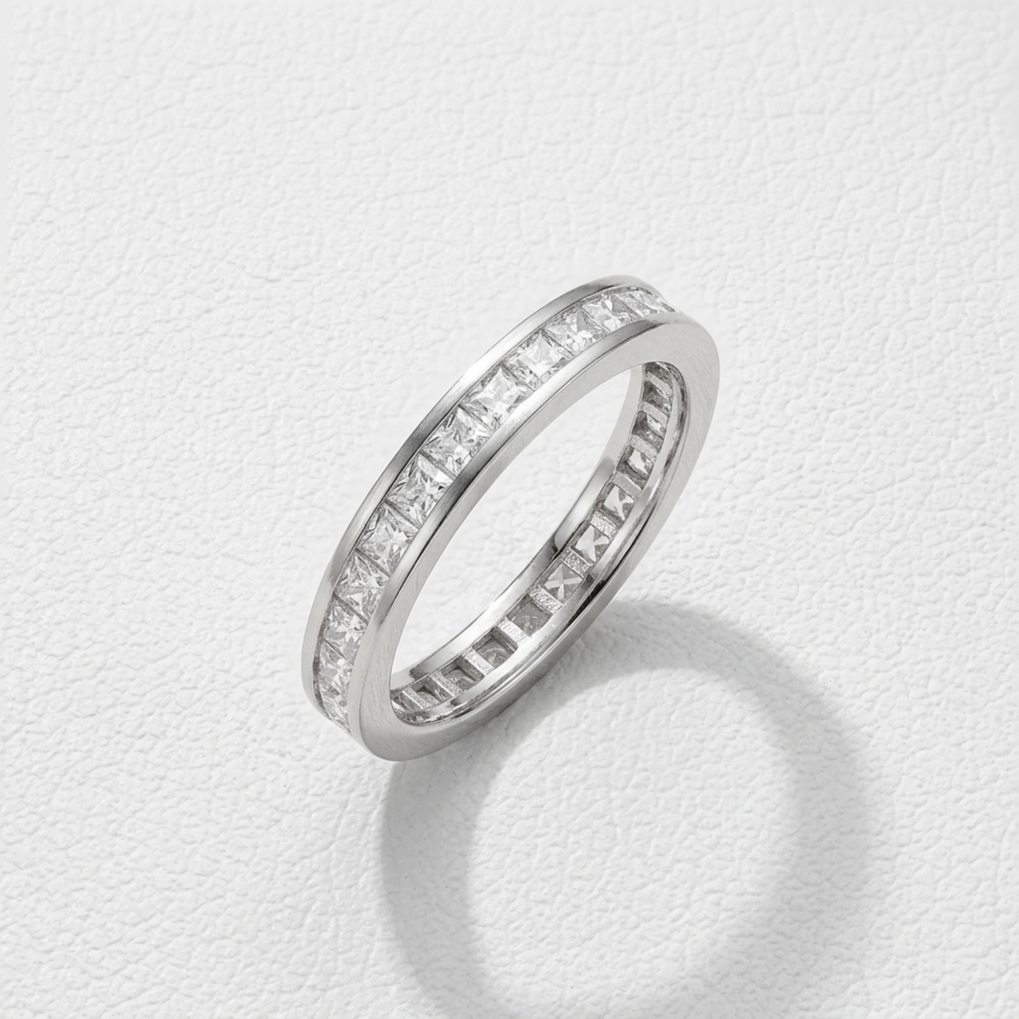 Silver-tone eternity ring, side view, with clear stones along the band