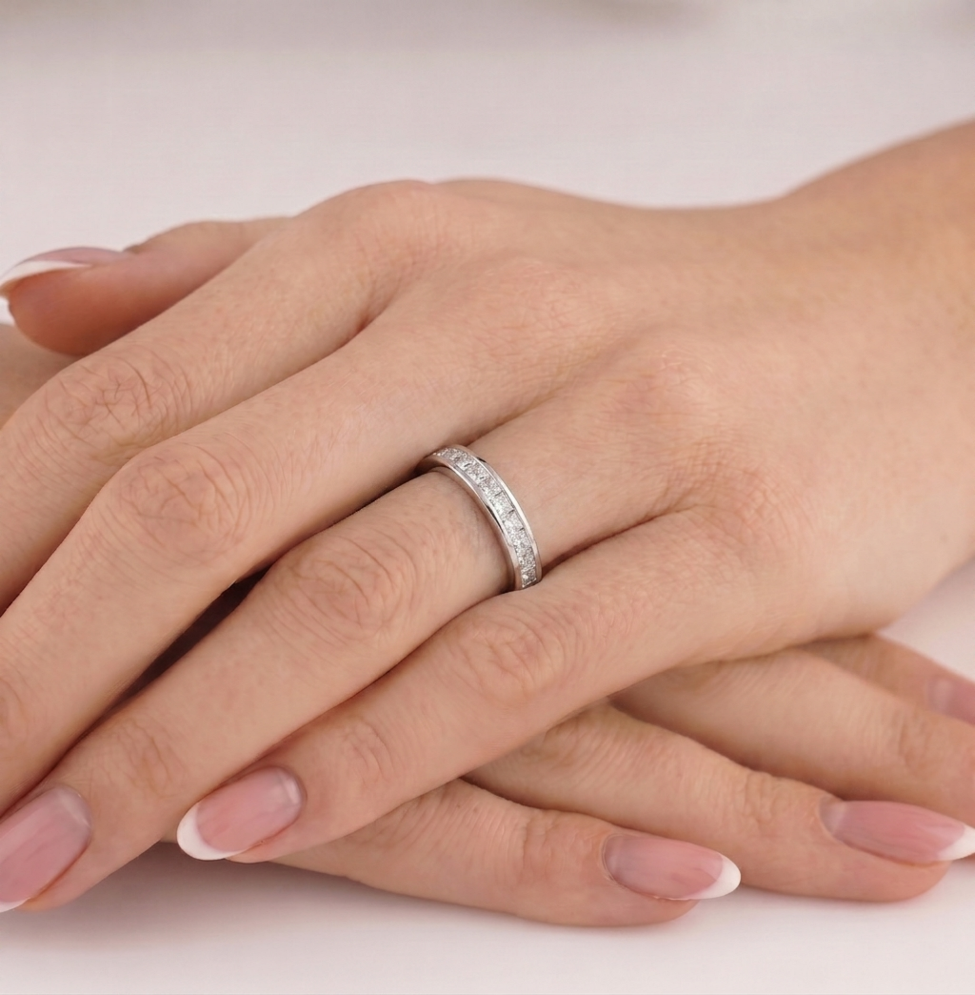 Silver-tone eternity ring with clear stones on hand