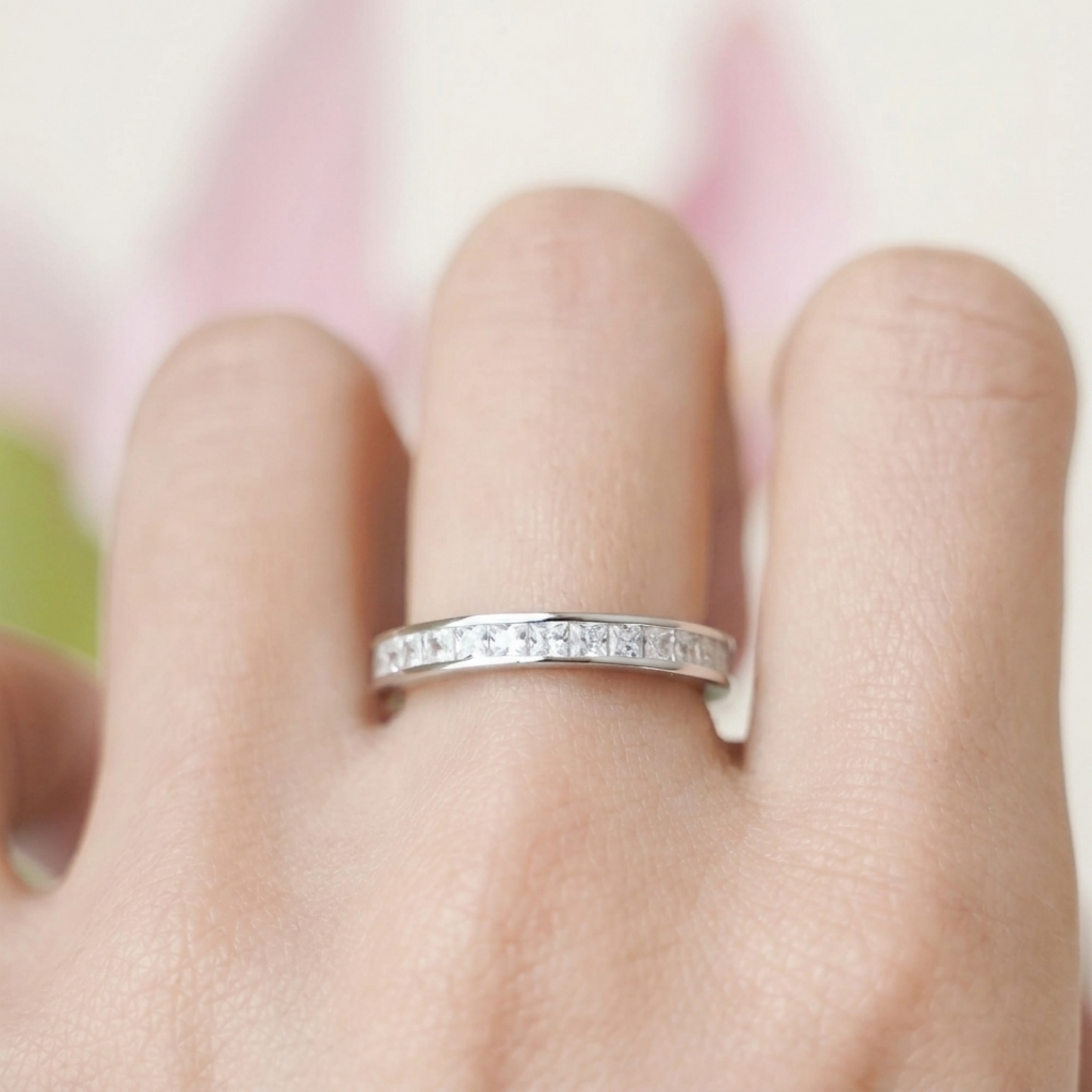 Silver-tone eternity ring with clear stone row on finger