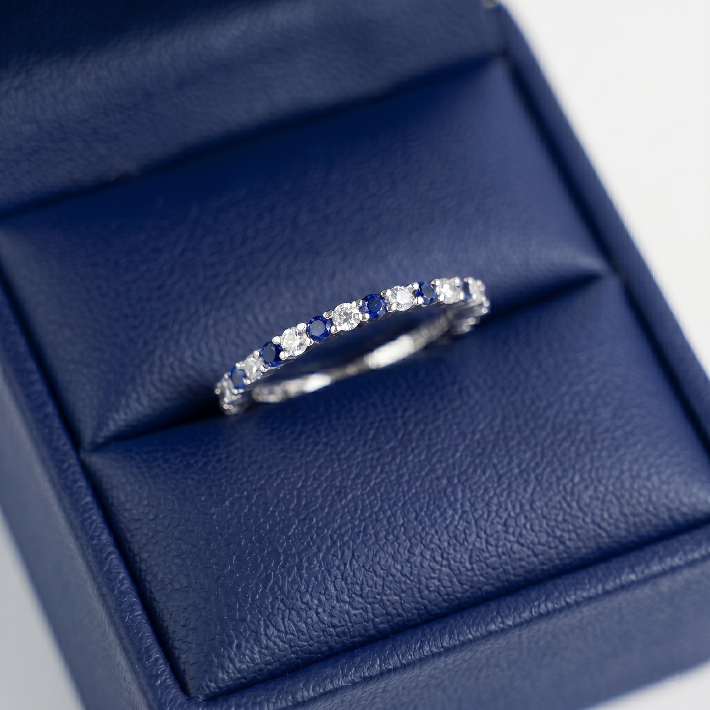 Sapphire Eternity Band with alternating round blue stones and clear stones, pavé band
