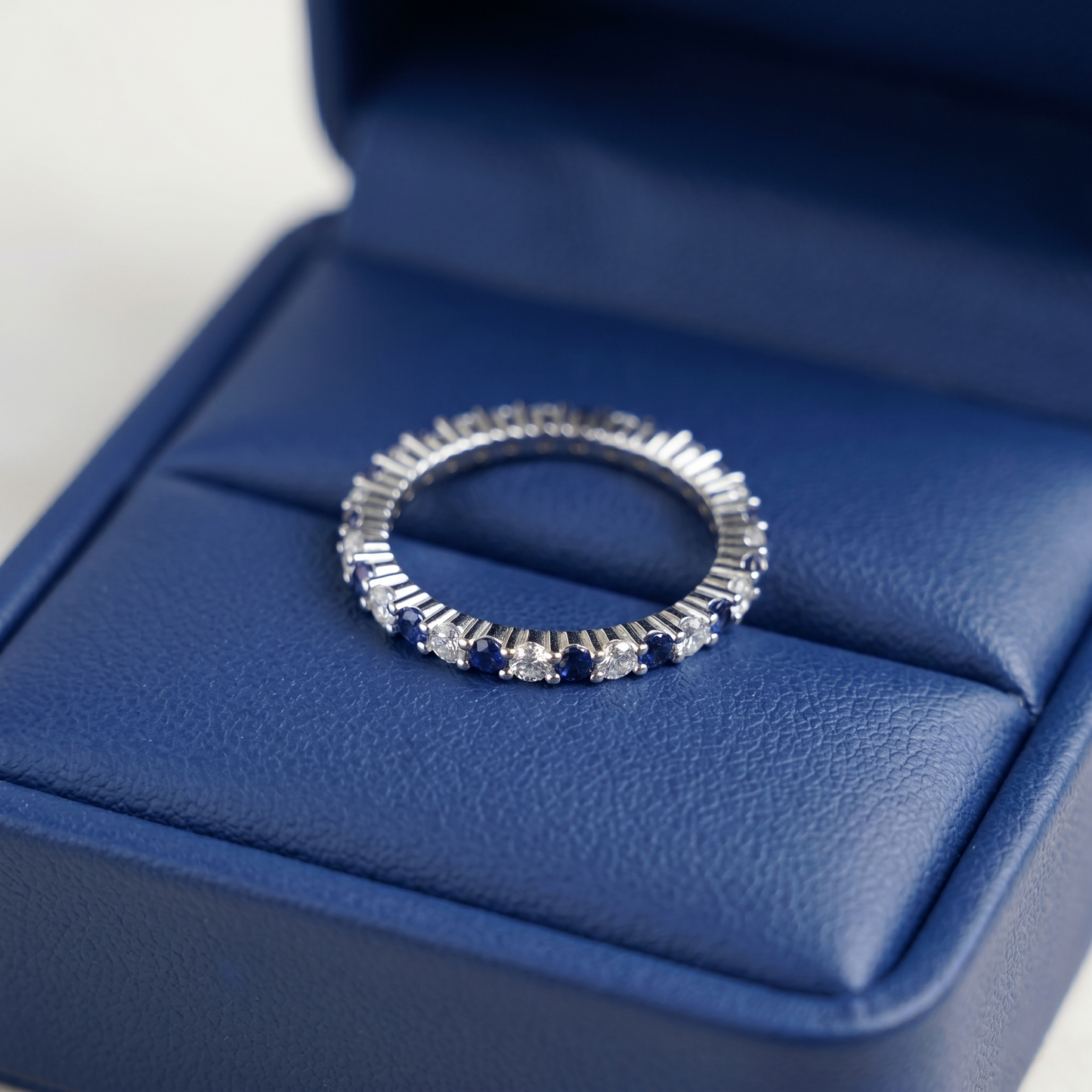 Sapphire Eternity Band top view in silver with blue stones across the band