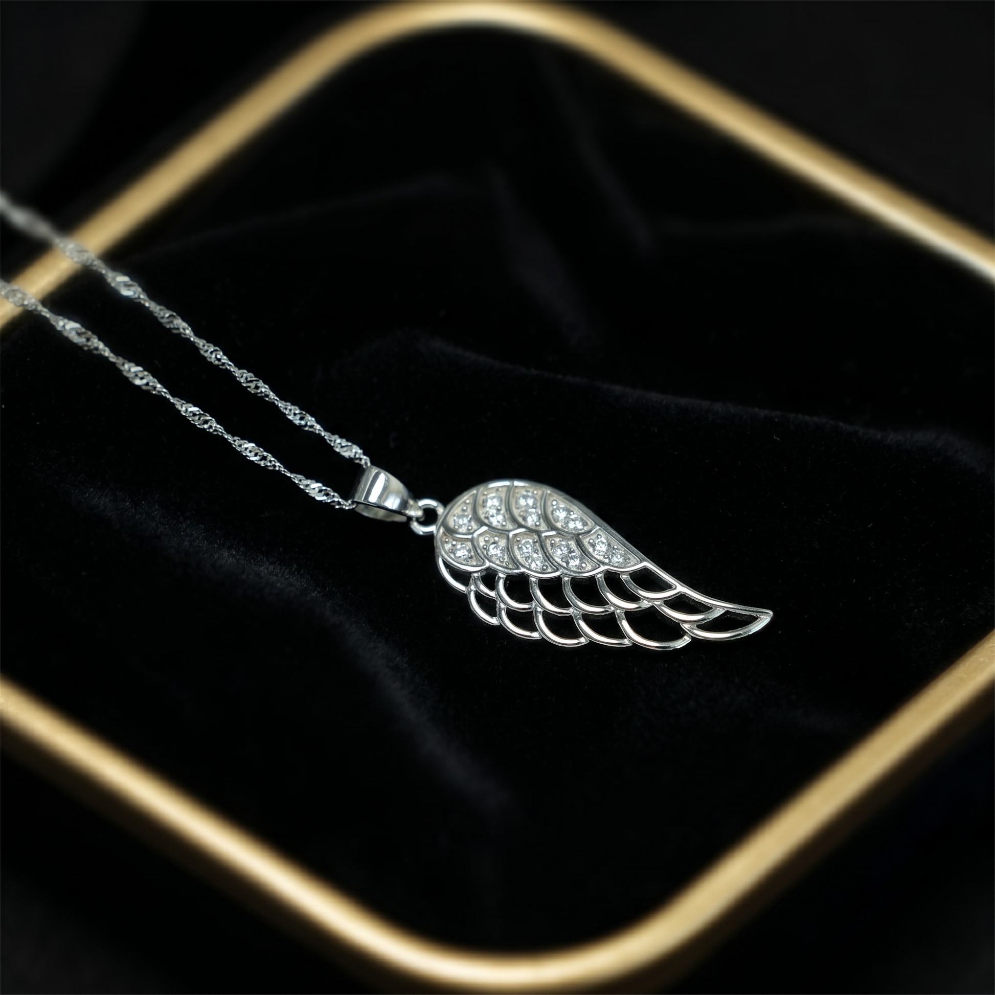Angel wing pendant with pavé detailing and a silver-tone chain link