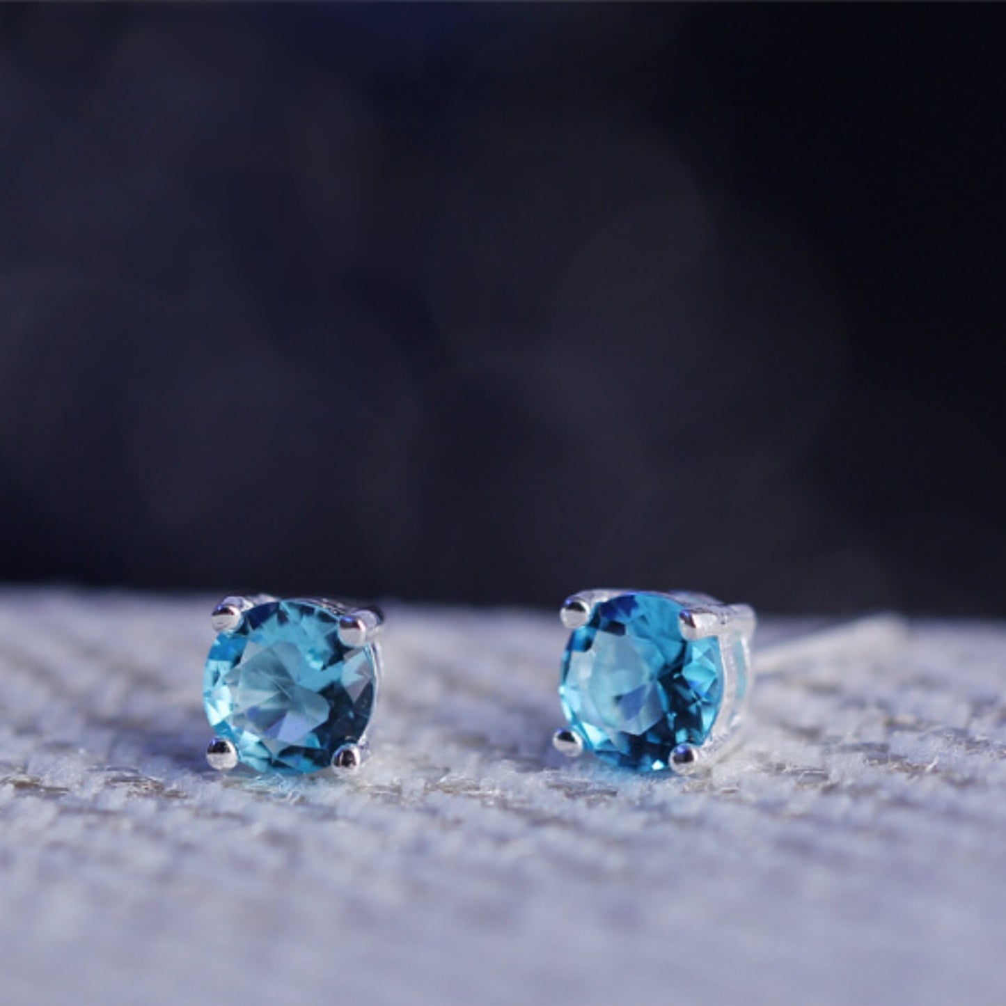 Round CZ solitaire stud earrings with light blue round stones on short posts