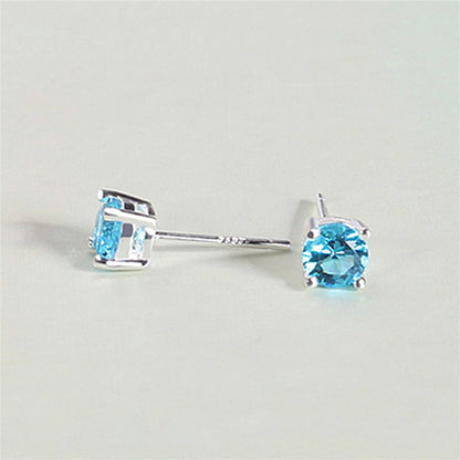 Round CZ solitaire stud earrings showing light blue round stones in prong-set frames