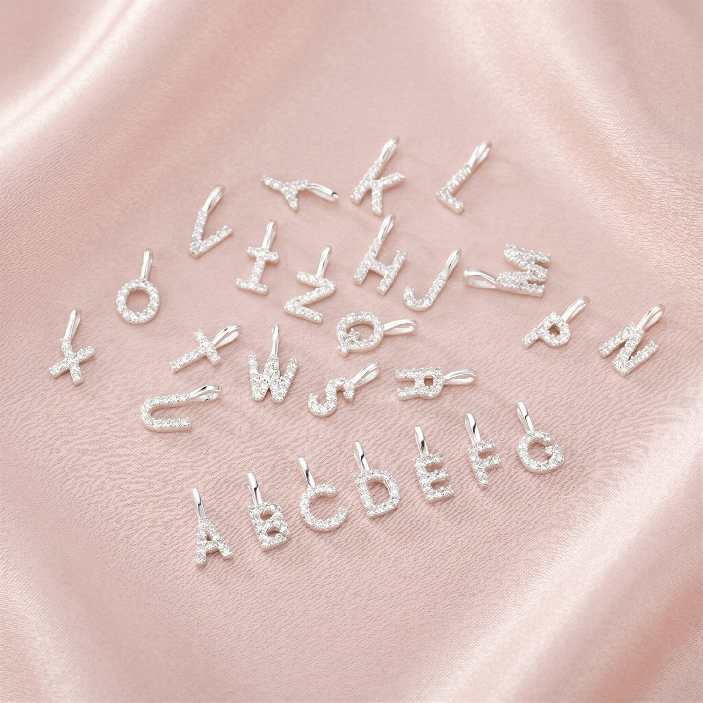 Assorted mini alphabet letter charms with rhinestone sparkle, close-up view