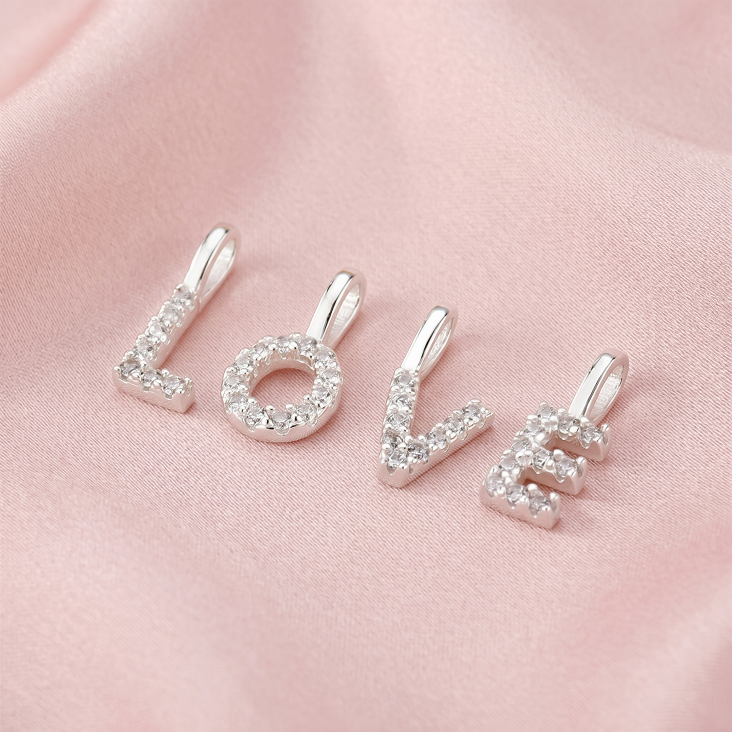 Three mini alphabet rhinestone letter charms on a chain, side view