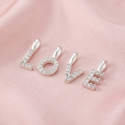 Three mini alphabet rhinestone letter charms on a chain, side view